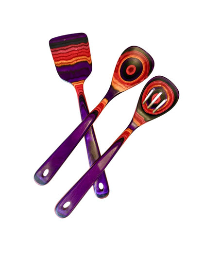 hree colorful layered-wood kitchen utensils—spatula, solid spoon, and slotted spoon—in purple, red, and orange tones on white background.