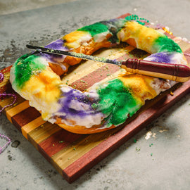 Carnival Board – handcrafted cutting and serving board in natural Purple Heart, Maple, and Sinker Cypress woods with juice well and handles, inspired by Mardi Gras