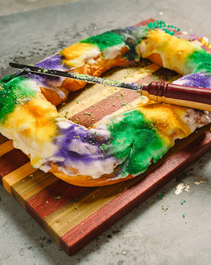 Carnival Board – handcrafted cutting and serving board in natural Purple Heart, Maple, and Sinker Cypress woods with juice well and handles, inspired by Mardi Gras