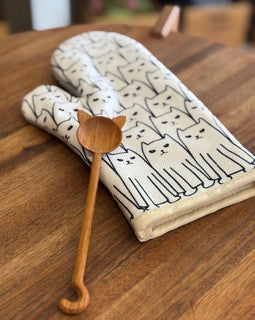 cat print oven mitt paired with wooden spoon featuring cat-shaped handle