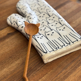 cat print oven mitt paired with wooden spoon featuring cat-shaped handle