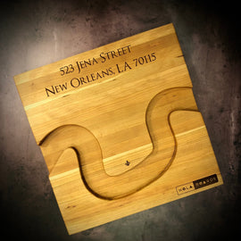 Handmade cherry Crescent City Board with curved edge holding crackers and olives, engraved with fleur de lis and address