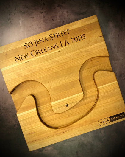 Handmade cherry Crescent City Board with curved edge holding crackers and olives, engraved with fleur de lis and address