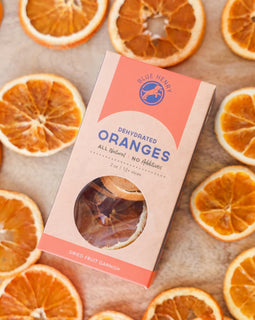 box of dehydrated orange slices for cocktail garnish surrounded by dried citrus slices