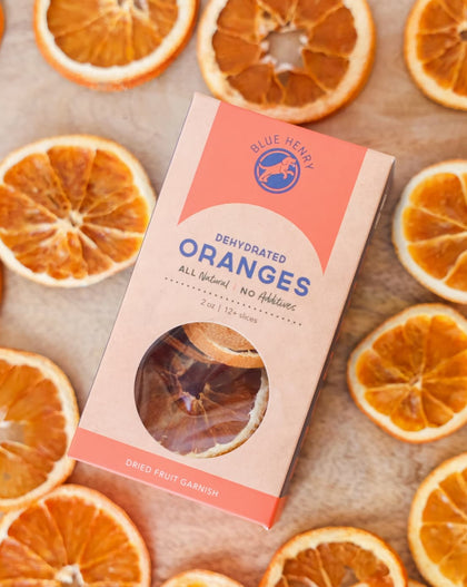 box of dehydrated orange slices for cocktail garnish surrounded by dried citrus slices