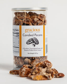 container of Gracious Bakery candied pecans with glazed pecans spilling out