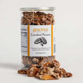 container of Gracious Bakery candied pecans with glazed pecans spilling out