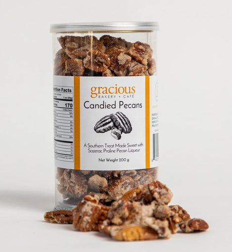 container of Gracious Bakery candied pecans with glazed pecans spilling out
