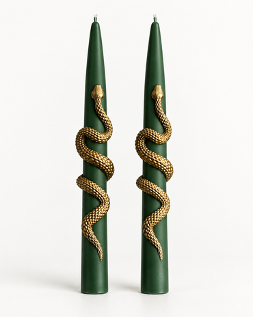 A pair of dark green taper candles with a detailed gold snake wrapped around each candle, set against a plain white background.