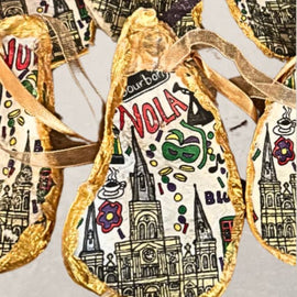 handpainted oyster shell ornament with New Orleans illustrations and gold edging