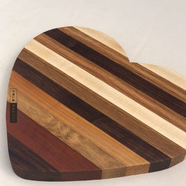 Heart shaped wooden cutting board made from mixed hardwoods with natural grain patterns, perfect for charcuterie and serving
