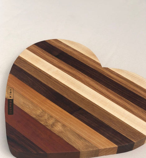 Heart shaped wooden cutting board made from mixed hardwoods with natural grain patterns, perfect for charcuterie and serving