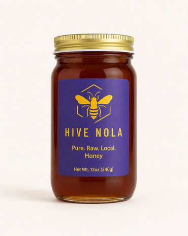 Jar of Hive Nola honey with a gold lid on a white background