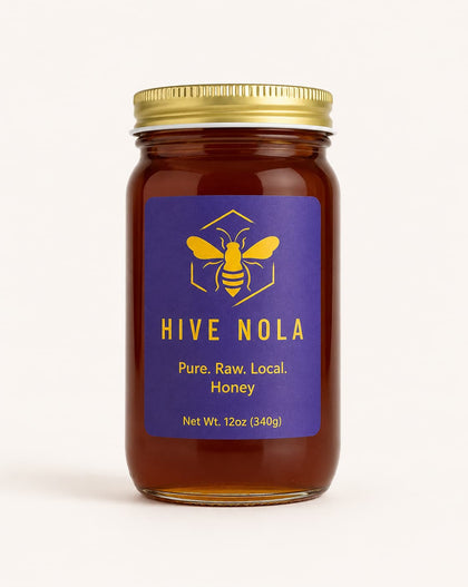 Jar of Hive Nola honey with a gold lid on a white background