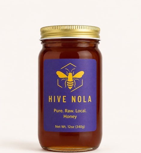 Jar of Hive Nola honey with a gold lid on a white background