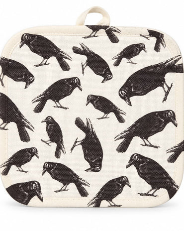Cream pot holder with vintage-style black raven print displayed on a kitchen countertop.
