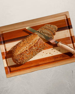 Roux mixed wood cutting board with cherry, maple, and walnut, featuring juice groove and handles, inspired by Louisiana cooking tradition