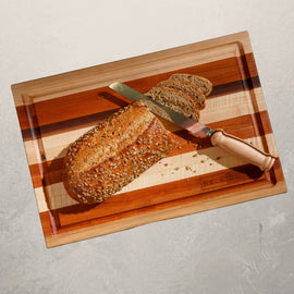 Roux mixed wood cutting board with cherry, maple, and walnut, featuring juice groove and handles, inspired by Louisiana cooking tradition
