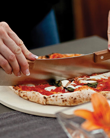 Stainless steel pizza rocker with artisan-style acacia wood handle and clear edge protector, 13-inch blade