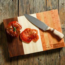 Trinity Board with cut tomato and knife on surface